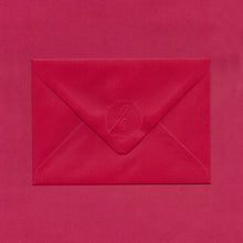 Load image into Gallery viewer, A festive red envelope, the flap embossed with the Elizabeth May Designs logo, on a red background
