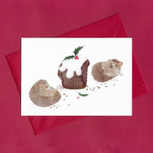 Load image into Gallery viewer, A hand drawn illustration on a greeting card of two hedgehogs lounging around surrounded by crumbs after eating too much Christmas pudding, with a Christmas pudding in the middle with huge bites missing. The card is on top of festive red envelope
