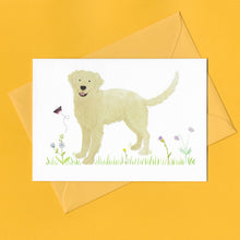 Load image into Gallery viewer, A stylised watercolour illustration on a luxury greeting card of a golden retriever dog amongst grass and wildflowers and a butterfly, with a bright yellow envelope, on a yellow background
