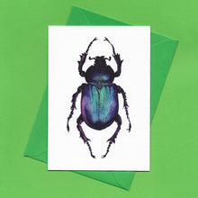 Load image into Gallery viewer, A detailed colour illustration on a luxury greeting card of a purple iridescent beetle, with a bright green envelope, sitting on a green background
